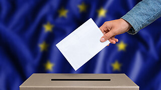 Vor dem Hintergrund einer EU-Flagge hält eine Hand einen Briefumschlag über eine Wahlurne