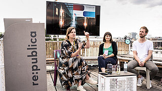 Anne Mollen, Friederike Rohde und Andreas Meyer halten einen Vortrag auf einer Dachterrasse der republica